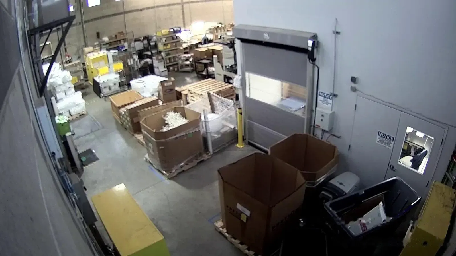 Camera view of a shipping and receiving area with a roll-up door